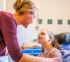 Pediatric nurse providing home nursing care for a child with cerebral palsy